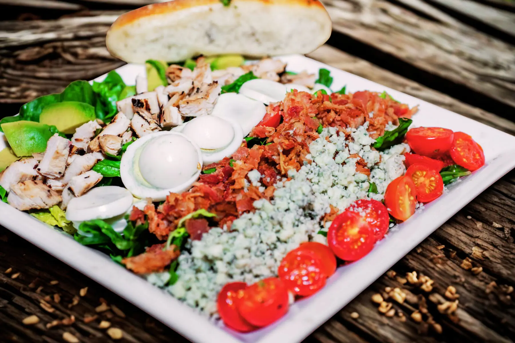 Cobb salad with chicken, eggs, bacon, tomatoes.